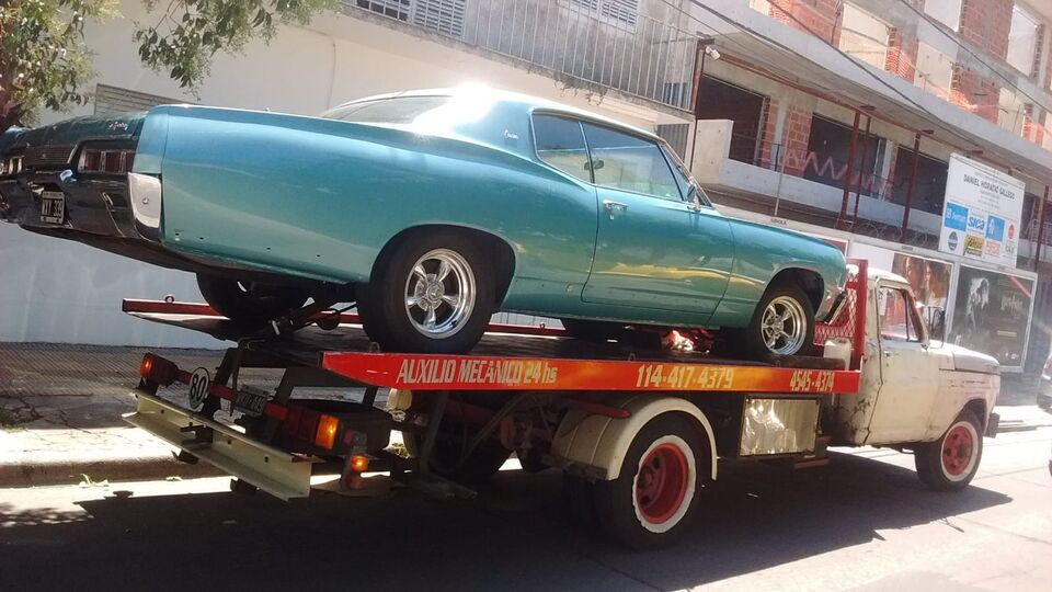 Grúa m-24 remolcando un auto clásico en Buenos Aires — auxilio mecánico 24 horas, tel 11-4417-4379 y 4545-4374 en la unidad.